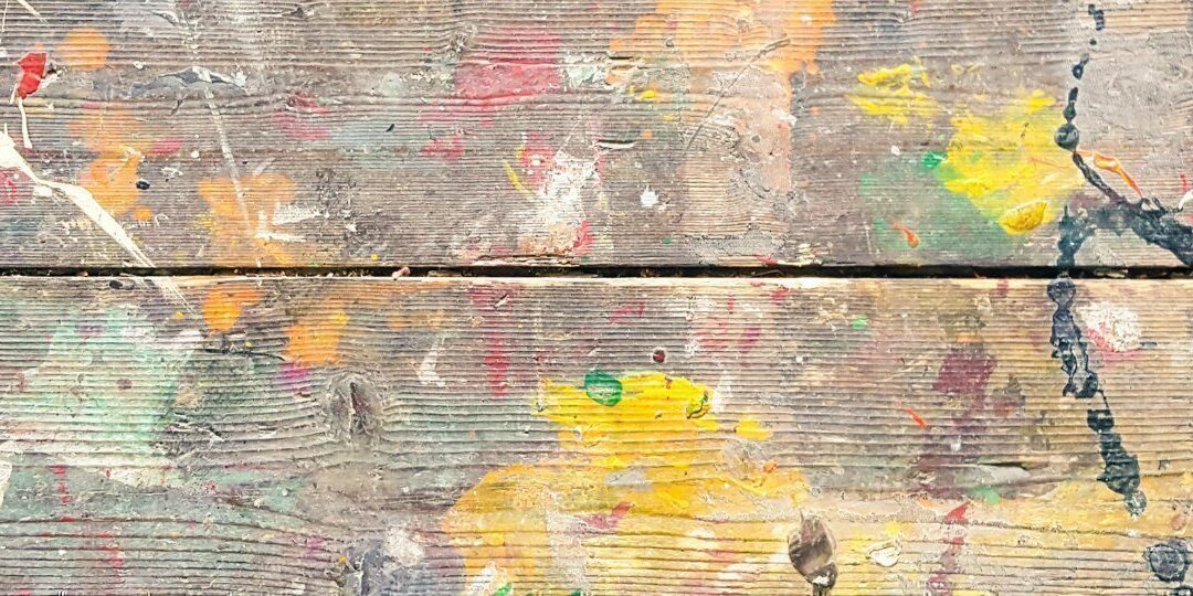 Old paint markings on a grained wooden floor.