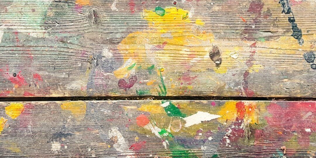 Old paint markings on a grained wooden floor.