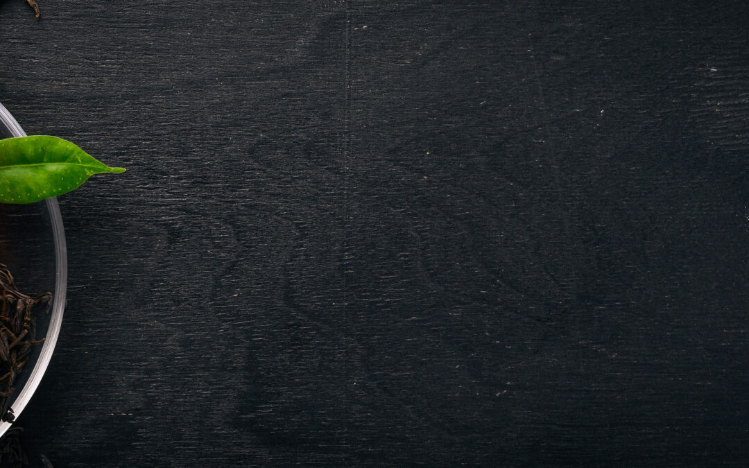 A cup of black tea on a wooden background. Top view. Copy space.